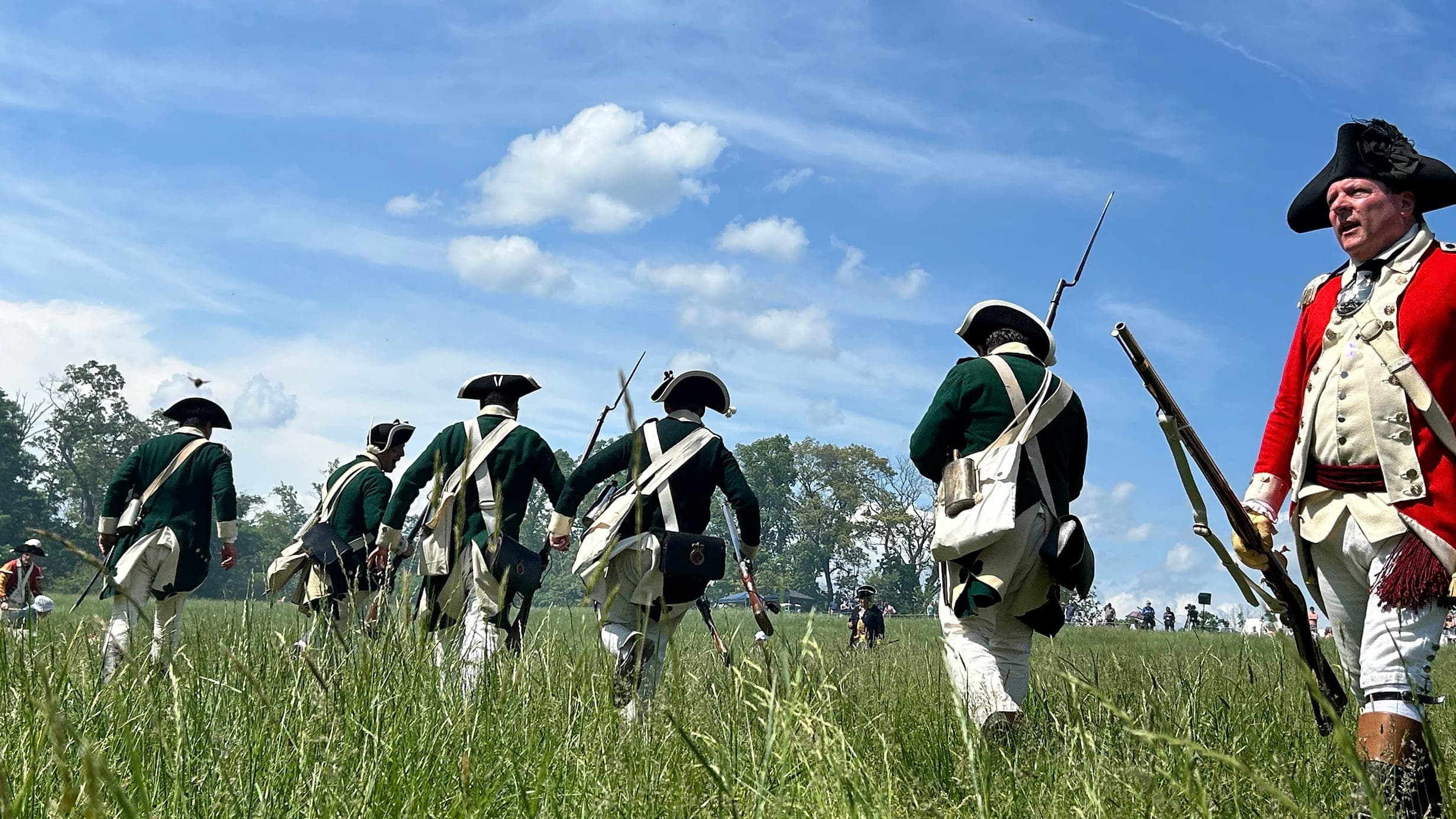 Revolutionary War soldiers walking away in a field.